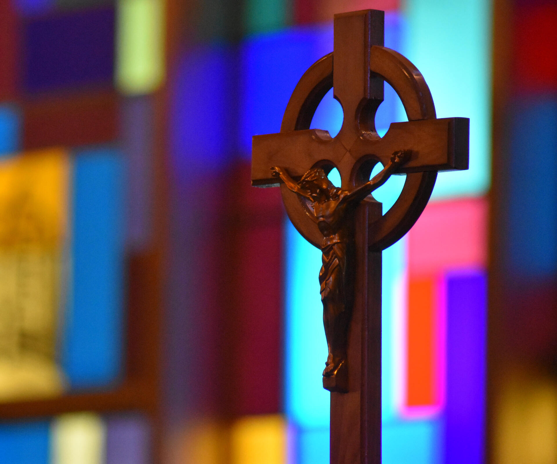 Crucifix A wooden crucifix at Holy Cross Lutheran Church in Racine, Wisconsin, set in front of the out-of-focus stained glass windows.